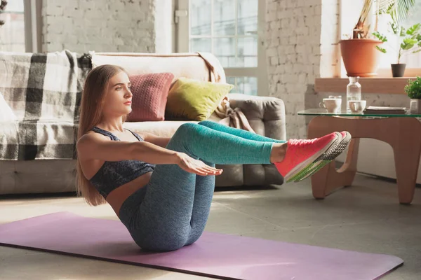 Jonge vrouw geeft thuis online cursussen fitness, aerobic, sportieve levensstijl terwijl ze in quarantaine is — Stockfoto