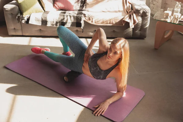 Jonge vrouw geeft thuis online cursussen fitness, aerobic, sportieve levensstijl terwijl ze in quarantaine is — Stockfoto
