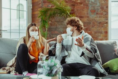 Kadın ve erkek, koruyucu maskeli ve eldivenli çift evde koronavirüs belirtileriyle izole edilmiş.