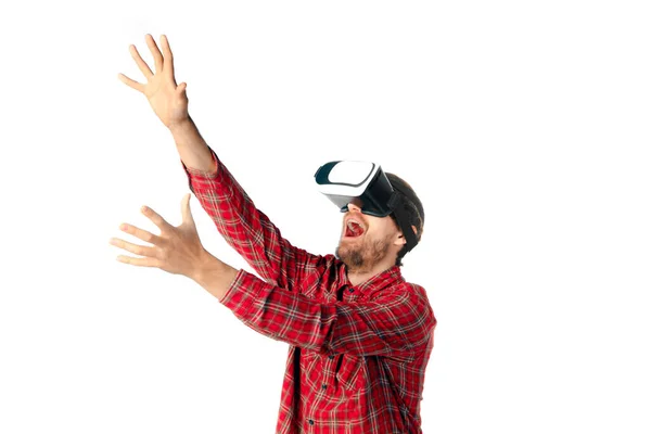 Hombre jugando emocional, utilizando auriculares de realidad virtual aislados en el fondo blanco del estudio — Foto de Stock