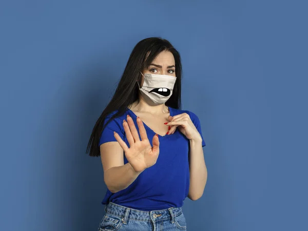 Portrait of young caucasian woman with emotion on her protective face mask — Stock Photo, Image