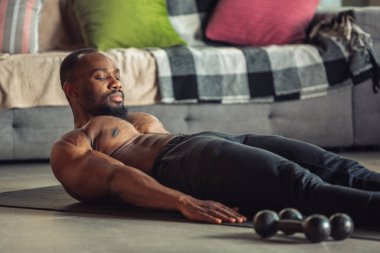 Genç Afro-Amerikalı erkek karantinadayken evde online spor, aerobik ve sportif yaşam dersleri veriyor.