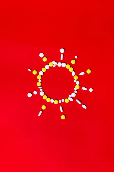 Pilules, comprimés et capsules de couleur sur fond rouge - antécédents de traitement, prévention de la pandémie — Photo