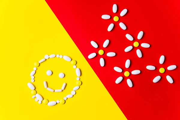 Pílulas coloridas, comprimidos e cápsulas em um fundo vermelho e amarelo - história de tratamento, prevenção de pandemia — Fotografia de Stock