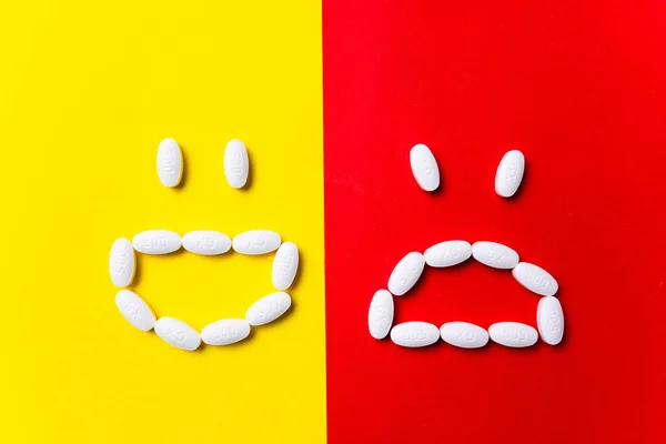 Gekleurde pillen, tabletten en capsules op een rode en gele achtergrond - voorgeschiedenis van behandeling, preventie van pandemie — Stockfoto