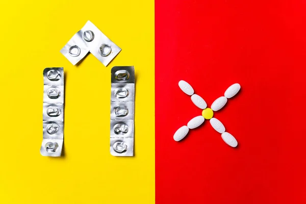 Кольорові таблетки, таблетки та капсули на червоно-жовтому тлі - історія лікування, профілактика пандемії — стокове фото