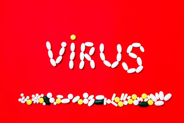 Färgade piller, tabletter och kapslar på en röd bakgrund - tidigare behandling, förebyggande av pandemi — Stockfoto