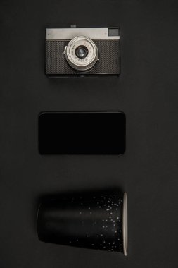 Gadget ve gözlük. Siyah renkte tek renkli kompozisyonda. Üst manzara, düz uzanma.