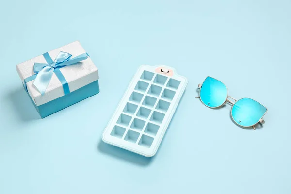 ギフト、プレゼントボックス、氷の形と眼鏡。モノクロームのスタイリッシュな構成がブルー。トップビュー、フラットレイアウト. — ストック写真