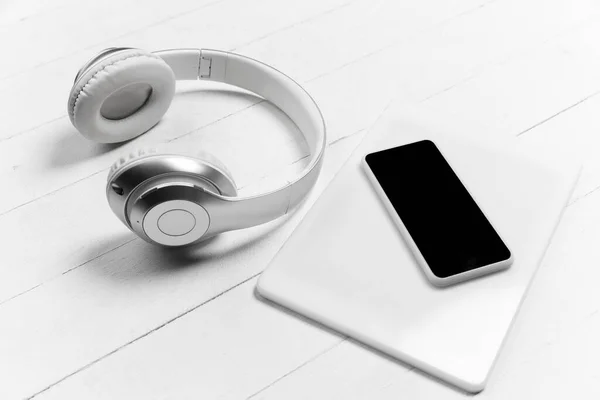 Smartphone y auriculares. Composición elegante monocromática en color blanco. Vista superior, plano . —  Fotos de Stock