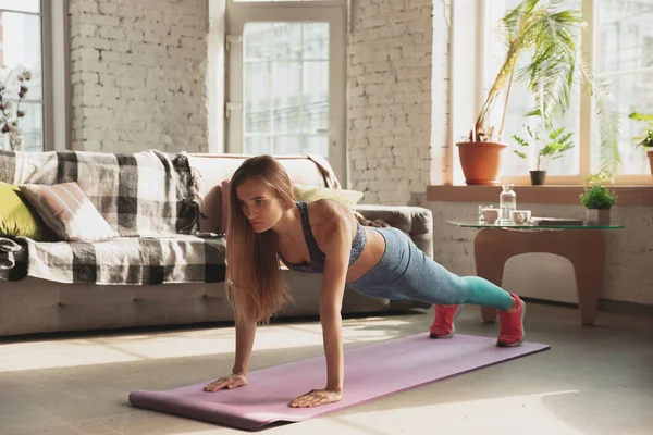 Young woman teaching at home online courses of fitness, aerobic, sporty lifestyle while being quarantine — Stock Photo, Image