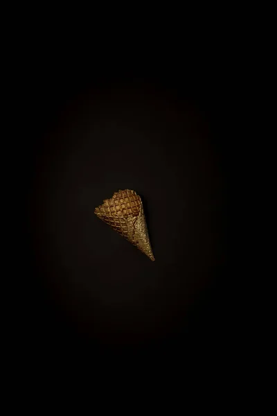 Gofre dorado helado sobre fondo negro, elegante composición minimalista con copyspace — Foto de Stock