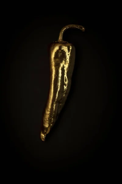 Pimenta dourada em um fundo preto, composição minimalista elegante com copyspace — Fotografia de Stock