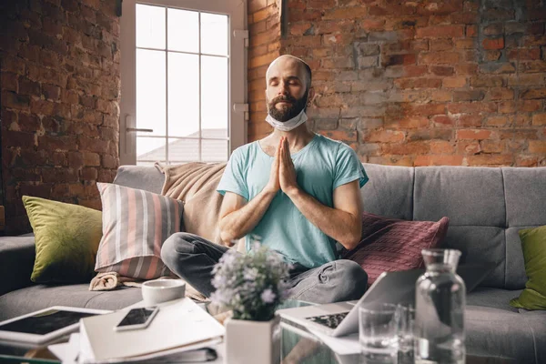 Joven haciendo yoga en casa mientras está en cuarentena y trabajando por cuenta propia — Foto de Stock