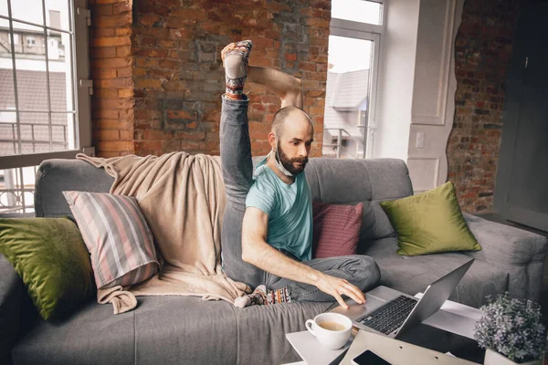 Joven haciendo yoga en casa mientras está en cuarentena y trabajando por cuenta propia — Foto de Stock