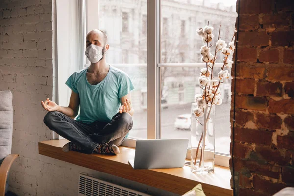 Joven haciendo yoga en casa mientras está en cuarentena y trabajando por cuenta propia — Foto de Stock