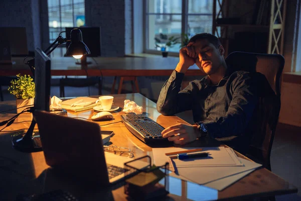 Homem trabalhando no escritório sozinho durante coronavírus ou quarentena COVID-19, ficando até tarde da noite — Fotografia de Stock