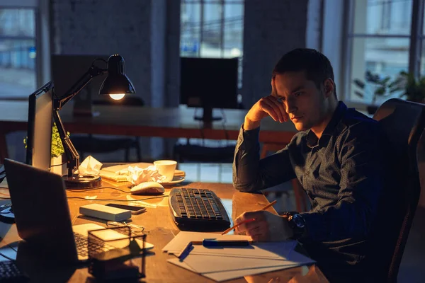 Man working in office alone during coronavirus or COVID-19 quarantine, staying to late night — Stock Photo, Image