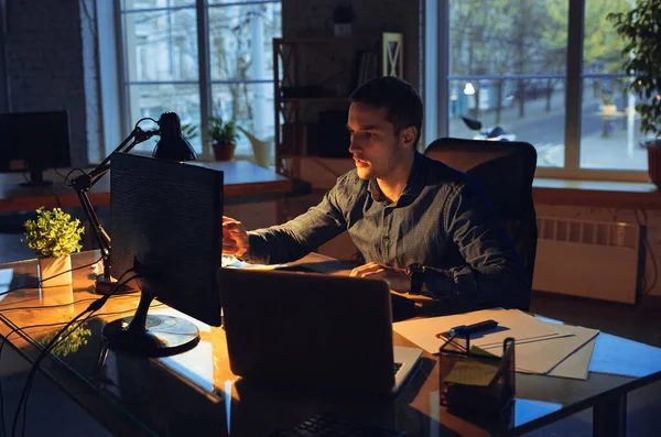 Man working in office alone during coronavirus or COVID-19 quarantine, staying to late night — Stock Photo, Image