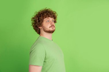 Yeşil stüdyo arka planında tek renkli beyaz adam portresi