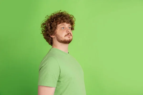 Blanke jonge mannen monochrome portret op groene studio achtergrond — Stockfoto