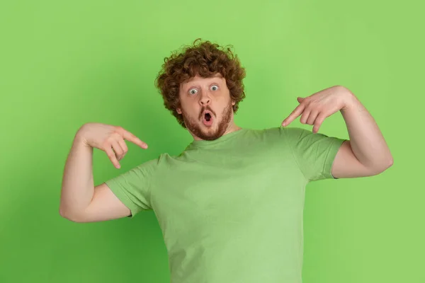 Caucasian young mans monochrome portrait on green studio background — Stock Photo, Image