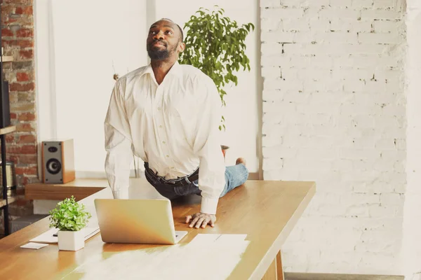 Junger afrikanisch-amerikanischer Mann macht Yoga zu Hause, während er unter Quarantäne steht und freiberuflich arbeitet — Stockfoto