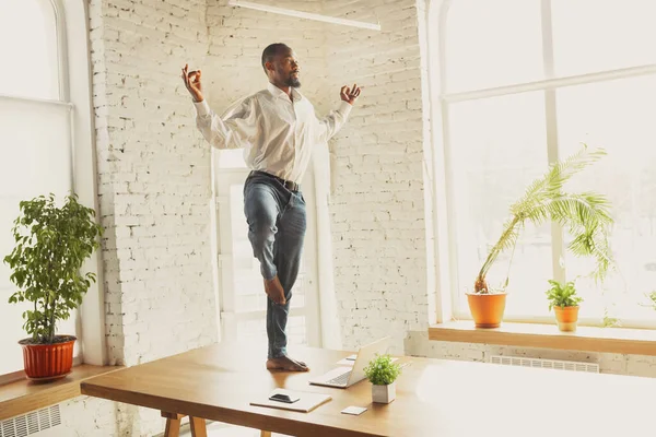 Junger afrikanisch-amerikanischer Mann macht Yoga zu Hause, während er unter Quarantäne steht und freiberuflich arbeitet — Stockfoto
