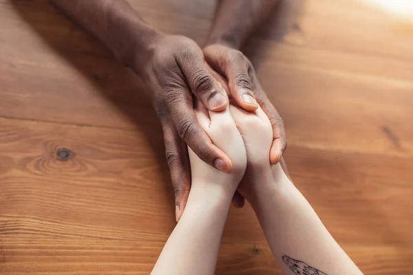 Close up of african-american male and caucasian female hands holding — Stock Photo, Image
