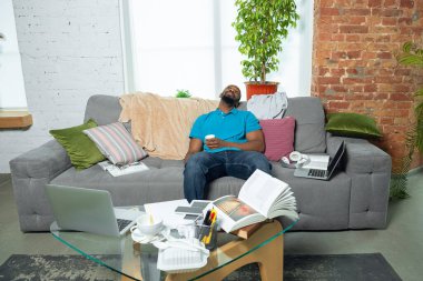 Koronavirüsün yayılması nedeniyle karantina sırasında evde kalan Afro-Amerikalı bir adam.