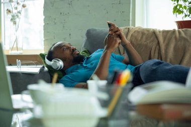 Koronavirüsün yayılması nedeniyle karantina sırasında evde kalan Afro-Amerikalı bir adam.