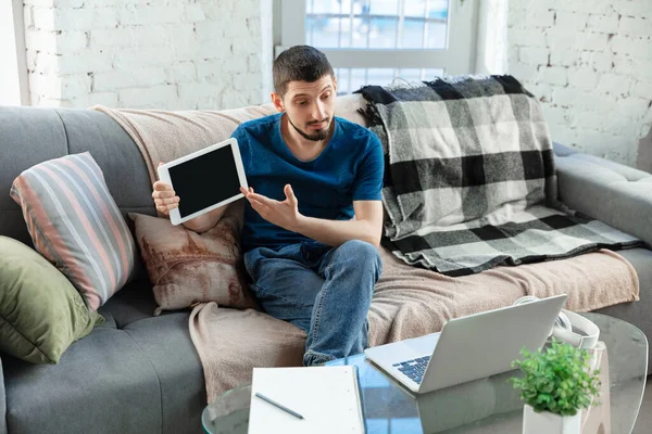 Jeune homme concentré étudiant à la maison pendant les cours en ligne ou des informations gratuites par lui-même — Photo