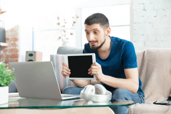 Mladý soustředěný muž studující doma během on-line kurzů nebo informace zdarma sám — Stock fotografie