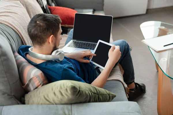 Jeune homme concentré étudiant à la maison pendant les cours en ligne ou des informations gratuites par lui-même — Photo