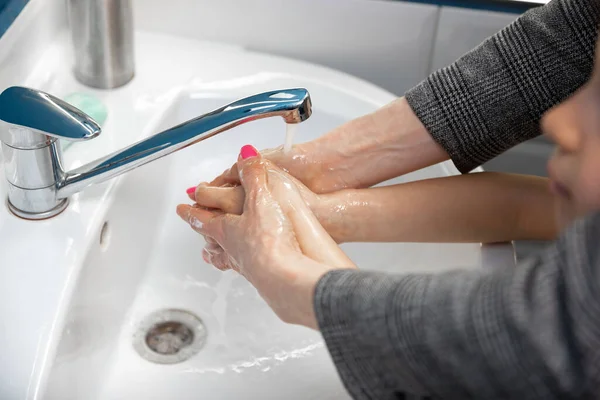Anya gondosan kezet mos a fiával a fürdőszobában. A fertőzés és a tüdőgyulladás vírussal való terjedésének megelőzése — Stock Fotó