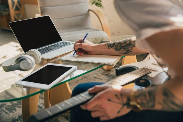 Çevrimiçi kurslar sırasında evde okuyan genç bir adam ya da kendi başına ücretsiz bilgi edinen biri.