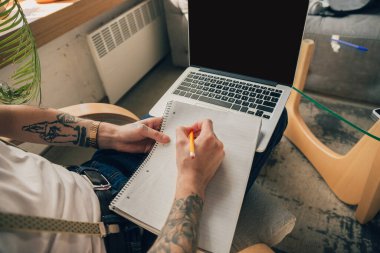 Çevrimiçi kurslar sırasında evde okuyan genç bir adam ya da kendi başına ücretsiz bilgi veren, online bir okul.