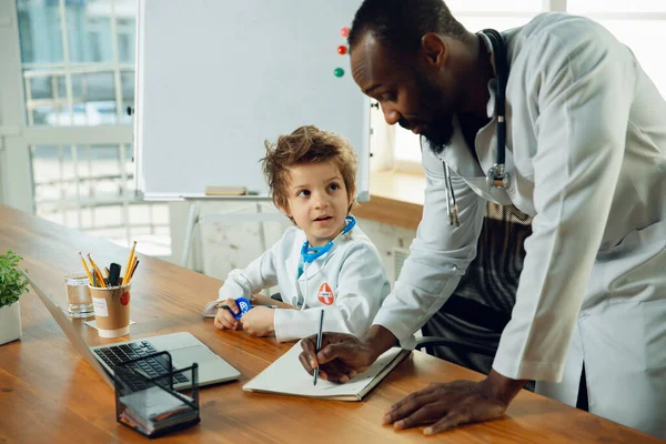 Little caucasian jongen als arts consulting voor patiënt, werken in het kabinet, close-up — Stockfoto