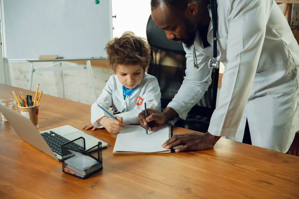 Little caucasian jongen als arts consulting voor patiënt, werken in het kabinet, close-up — Stockfoto