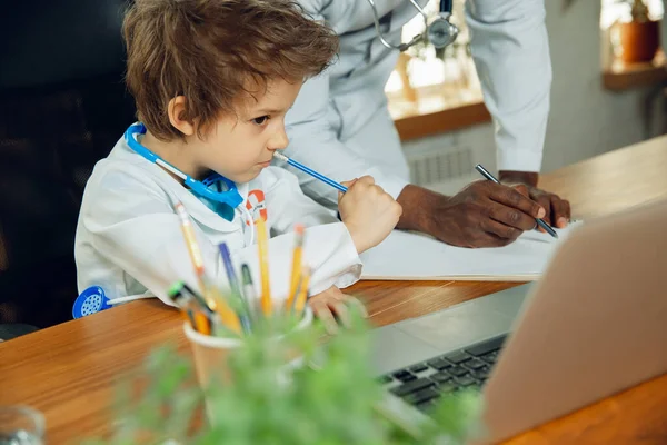 Little caucasian jongen als arts consulting voor patiënt, werken in het kabinet, close-up — Stockfoto