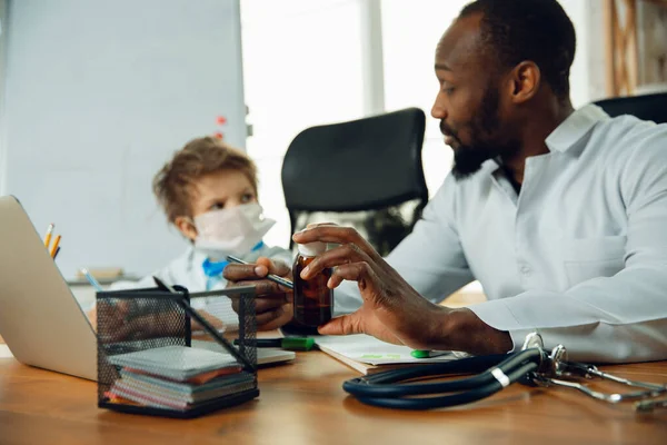 Little caucasian jongen als arts consulting voor patiënt, werken in het kabinet, close-up — Stockfoto