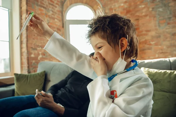 Little caucasian boy as a doctor consulting for patient, working in cabinet, close up