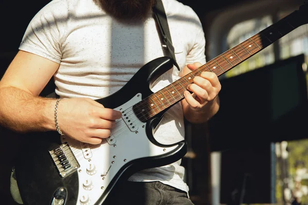 Músico caucasiano tocando guitarra durante concerto online em casa isolado e em quarentena, improvisação impressionante, close-up — Fotografia de Stock