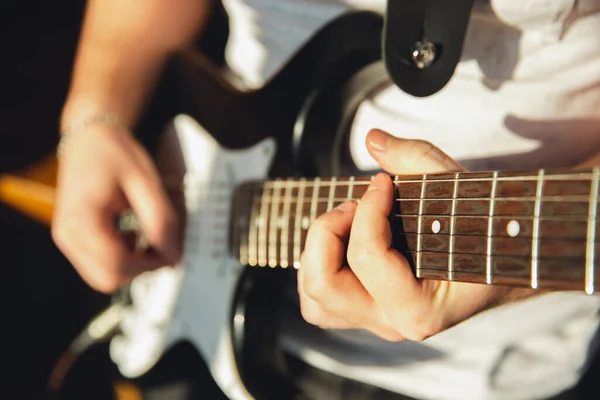 Músico caucásico tocando la guitarra durante el concierto en línea en casa aislado y en cuarentena, improvisación impresionante, de cerca — Foto de Stock