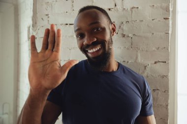 Afro-Amerikalı müzisyen beyaz tuğladan duvar arkasında neşeli ve mutlu.
