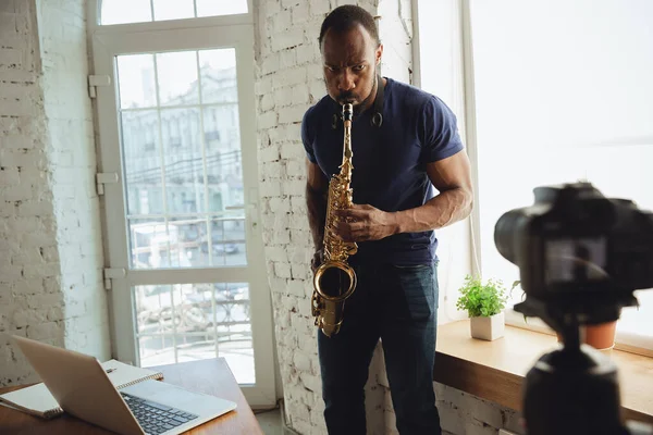 Afroamerikanischer Musiker spielt Saxofon bei Online-Konzert zu Hause isoliert und unter Quarantäne, improvisiert vor der Kamera — Stockfoto