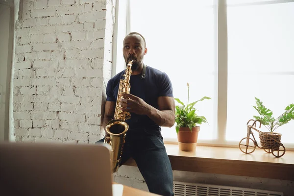 Afroamerikanischer Musiker spielt Saxofon bei Online-Konzert zu Hause isoliert und unter Quarantäne, beeindruckende Improvisation — Stockfoto