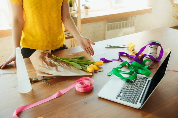 Florista en el trabajo: mujer muestra cómo hacer ramo con tulipanes, trabajar en el concepto de casa, elegir la decoración — Foto de Stock