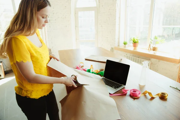 Florista en el trabajo: mujer muestra cómo hacer ramo con tulipanes, trabajando en el concepto de casa, preparando flores — Foto de Stock