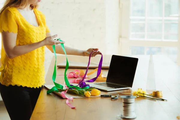 Флорист на работе: женщина показывает, как сделать букет из тюльпанов, работая на дому концепции, используя ленты — стоковое фото